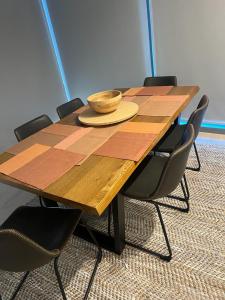 a wooden table with chairs and a bowl on it at Beautiful Ocean View Apartment Signature Broadbeach in Gold Coast