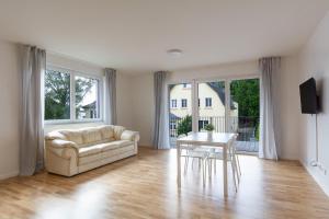 uma sala de estar com um sofá e uma mesa em T&K Apartments - Bergisch Gladbach - 7 Comfortable Apartments - 20 min to Fair Messe Cologne em Bergisch Gladbach