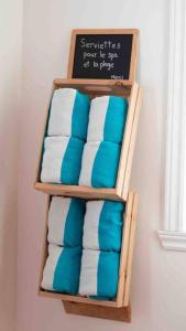 a wooden towel rack with towels on a wall at Chalet BIA - Le Petit Chaleureux in Ham Nord