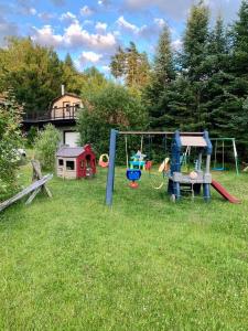 a yard with a playground in the grass at Chalet BIA - Le Petit Chaleureux in Ham Nord