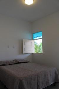 ein Schlafzimmer mit einem Bett und einem Fenster in der Unterkunft Casa temporada Tamandaré Carneiros in Tamandaré