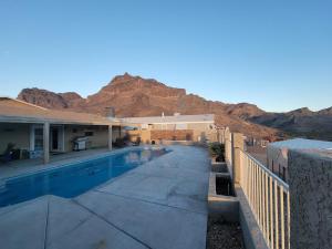a house with a swimming pool in front of a mountain at Parker Strip pool house with game room! in Parker