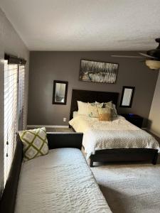 a bedroom with a bed and a couch in it at Parker Strip pool house with game room! in Parker