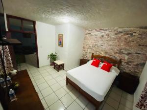 a bedroom with a bed and a brick wall at Hotel Fernando´s in Tlalpujahua de Rayón