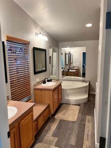 a large bathroom with a tub and a sink at Parker Strip pool house with game room! in Parker