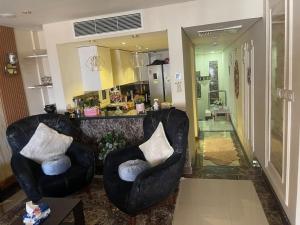 a living room with two chairs and a kitchen at Classy 2 floors with 2pools in NC in Cairo