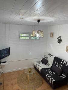Sala de estar con sofá en blanco y negro y mesa en Residence Les Palmiers, en La Trinité