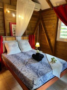 a bedroom with a bed with a blue comforter at Fetay Jaune in Baie-Mahault