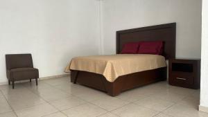 a bedroom with a large bed and a chair at CASA BRAVO in Huamantla