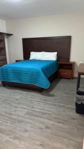 a bedroom with a bed with a blue comforter at CASA BRAVO in Huamantla