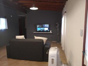 a living room with a couch and a tv at Villa Escondida in Mar del Plata