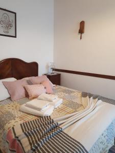 a bed with a blanket and books on it at Casa do Sr. Alberto in Praia da Vitória