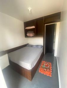 ein kleines Schlafzimmer mit einem Bett und einem orangefarbenen Teppich in der Unterkunft Dormitórios ponto 37 in Treviso
