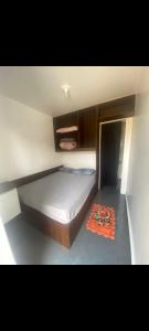 ein kleines Schlafzimmer mit einem Bett und einem orangefarbenen Teppich in der Unterkunft Dormitórios ponto 37 in Treviso