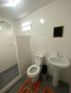 a white bathroom with a toilet and a sink at Dormitórios ponto 37 in Treviso