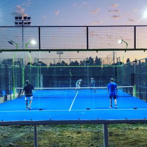 a group of people playing tennis on a tennis court at Parronales de Los Boldos in Santa Cruz