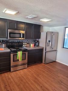 a kitchen with black cabinets and stainless steel appliances at Riverfront Escape with boat dock! in Parker