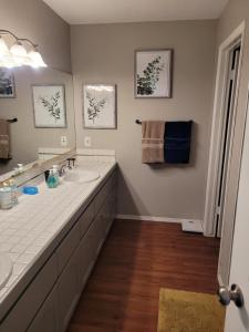 a bathroom with two sinks and a large mirror at Riverfront Escape with boat dock! in Parker