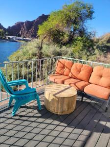 a couch and a chair and a coffee table on a deck at Riverfront Escape with boat dock! in Parker