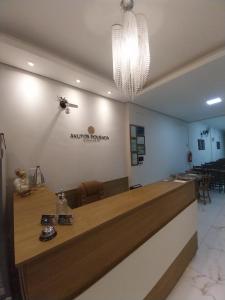 a reception desk with a chandelier in a room at Aparecida Akuto's Pousada in Aparecida