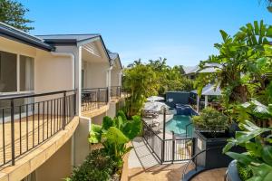 an apartment balcony with plants and a swimming pool at Eco Beach Resort in Byron Bay
