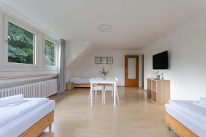 a room with a table and two beds and a tv at T&K Apartments - 3 Room Apartment in Mülheim an der Ruhr