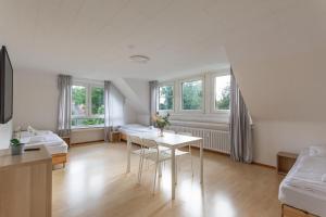 a living room with a table and two beds at T&K Apartments - 3 Room Apartment in Mülheim an der Ruhr +8 photos