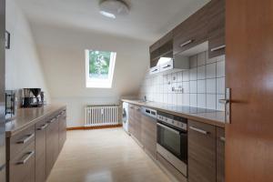 a large kitchen with wooden cabinets and appliances at T&K Apartments - 3 Room Apartment in Mülheim an der Ruhr