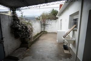 eine leere Gasse mit einer weißen Wand und einem Waschbecken in der Unterkunft Casa amueblada en centro de Minas, Lavalleja in Minas