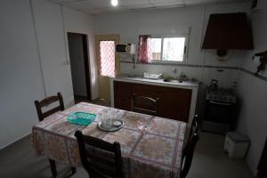 eine Küche mit einem Tisch mit Stühlen und einem Herd in der Unterkunft Casa amueblada en centro de Minas, Lavalleja in Minas