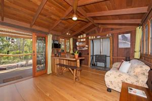 a living room with a couch and a desk in a house at MANGO LODGE River Heads in River Heads