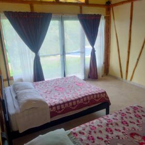 1 Schlafzimmer mit 2 Betten vor einem Fenster in der Unterkunft Quinta Maka VistaHermosa in Villeta