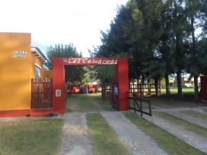 Una puerta a un parque con un cartel. en Las Casuarinas Claromeco en Balneario Claromecó