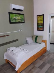 niewielka sypialnia z łóżkiem z białą pościelą w obiekcie Las Casuarinas Claromeco w mieście Balneario Claromecó