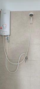 a white hose hooked up to a shower in a bathroom at Moon Travel Phangan in Ban Nua