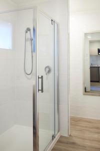 a shower with a glass door in a bathroom at Emerald Inn on Takapuna Beach in Auckland