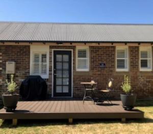 una terrazza in legno di fronte a una casa di mattoni di The Stables ad Armidale