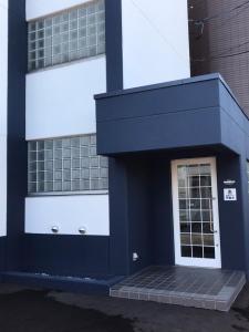a blue and white building with a door at NORTH LIVE 2 in Ōdōri