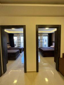 two mirrors in a room with two beds and a living room at Modern 2bedroom For Rent Abdoun in Amman