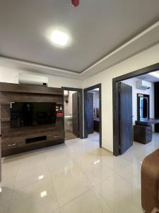 a living room with a large television and a couch at Modern 2bedroom For Rent Abdoun in Amman