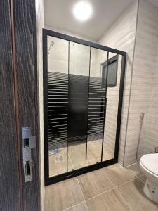 a bathroom with a glass shower with a toilet at Modern 2bedroom For Rent Abdoun in Amman