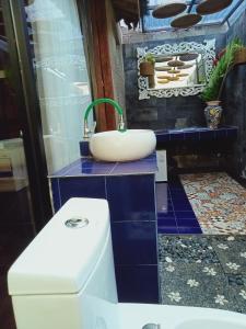 y baño con lavabo y aseo. en Buratwangi Joglo House, en Kerobokan