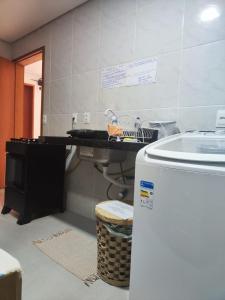uma cozinha com um balcão, um lavatório e um frigorífico em Casa Sagrada 282 em Fortaleza