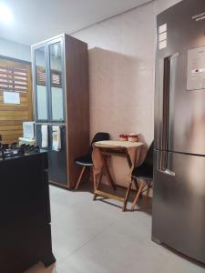 uma cozinha com uma mesa e um frigorífico em Casa Sagrada 282 em Fortaleza