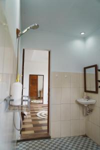 a bathroom with a sink and a mirror at Nyaman Villa Ubud - Gemütliche Wohnung in Reisfelder in Ubud