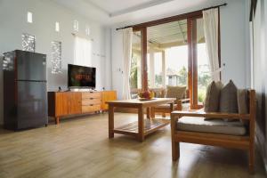 a living room with a refrigerator and a table at Nyaman Villa Ubud - Gemütliche Wohnung in Reisfelder in Ubud