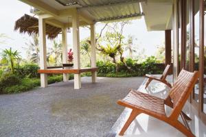 a porch with two benches on a house at Nyaman Villa Ubud in Ubud