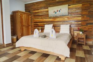 a bedroom with a bed with a wooden wall at Nyaman Villa Ubud in Ubud