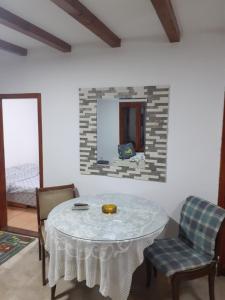 Zimmer mit einem Tisch, 2 Stühlen und einem Spiegel in der Unterkunft Apartman Vidikovac in Varna