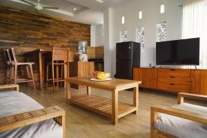 a living room with a television and a table at Nyaman Villa Ubud in Ubud